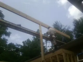 Carpenter setting a ridge beam over a new addition frame — Ice Dam Removal by Roofing Brothers in Marina Del Rey